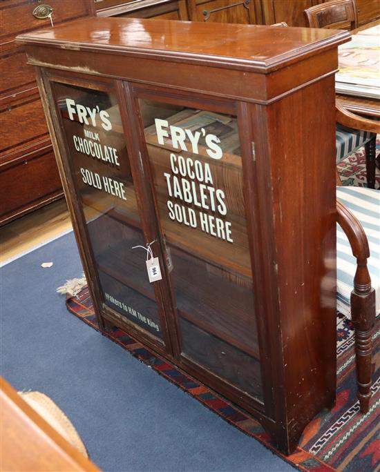 A late Victorian walnut two door bookcase, the doors later painted with the Frys chocolate logo W.92cm
